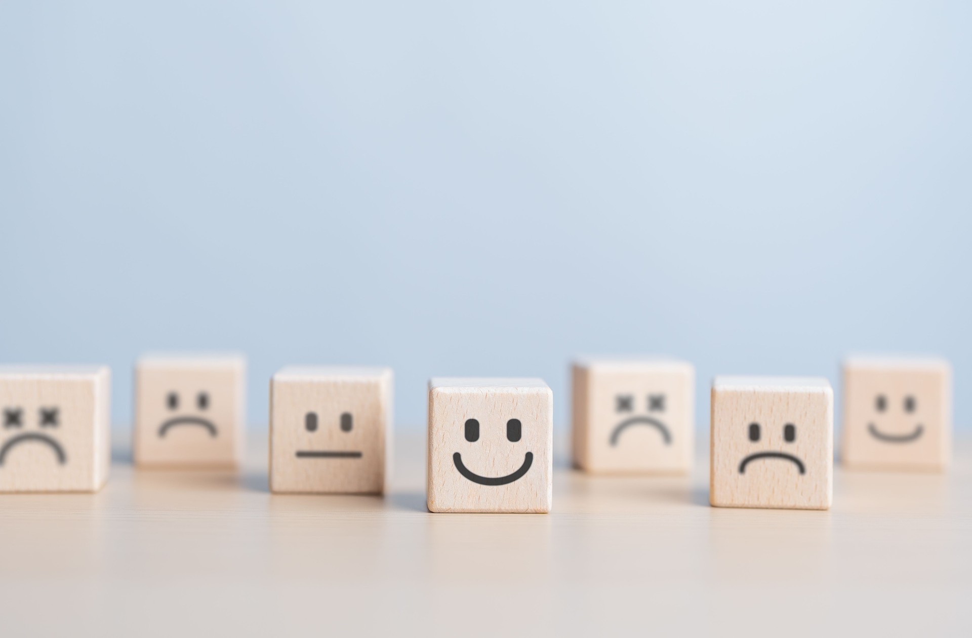 Introvert, Individual person. Unique man is happy and enjoy isolation. Separation or Solitude person. Wooden figure with happy face split line from the crowd. World Mental Health Day, emotion concept.